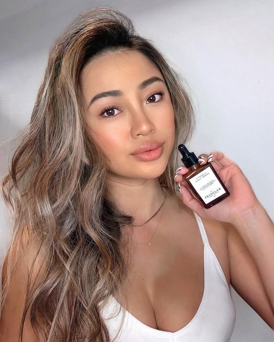 beautiful woman showing Vitamin A Night Serum in her hand