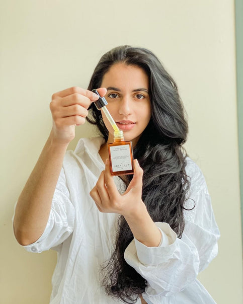 beautiful woman showing Vitamin A Night Serum in her hands